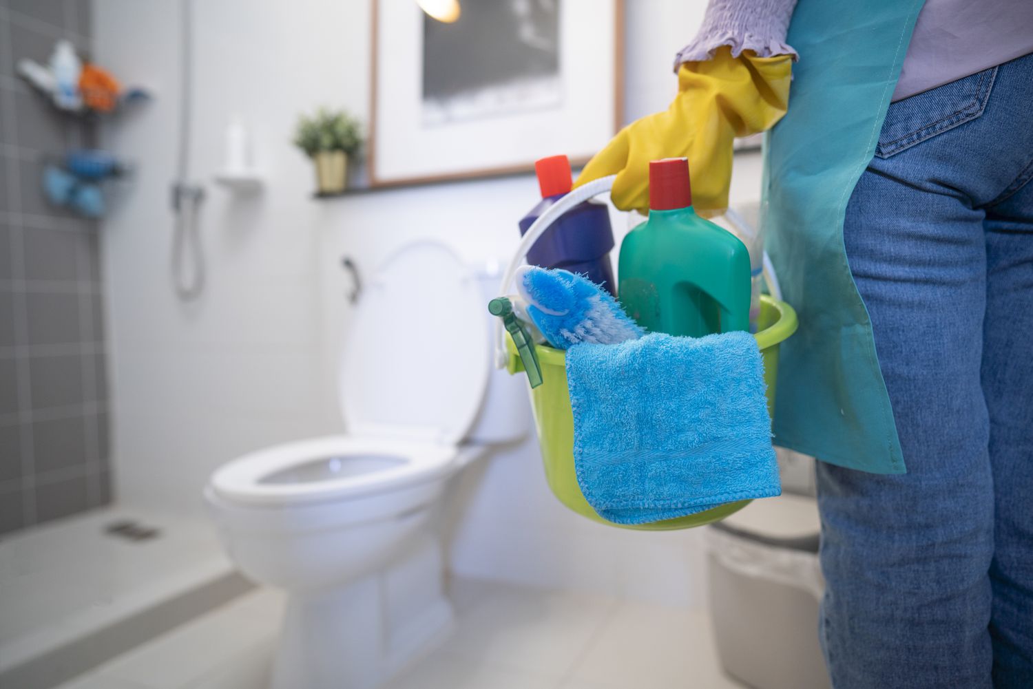 Cleaner deep cleaning a bathroom with eco-friendly products